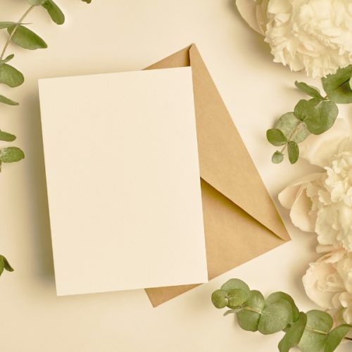 Stationery and flowers against white background